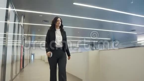 自信的女商人在一栋办公楼里走下大厅穿黑色西装的年轻女人视频的预览图