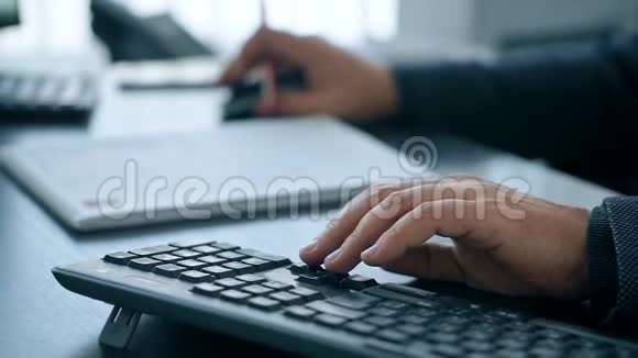 手在电脑键盘上打字男人在办公室工作视频的预览图