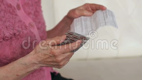 一位老太太手里的手册和药片视频的预览图
