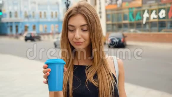 城市里美丽的年轻女人的肖像开心地笑喝着美味的咖啡视频的预览图