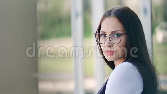 肖像美丽的年轻成功女商人戴着眼镜冷静而体贴地看着相机视频的预览图