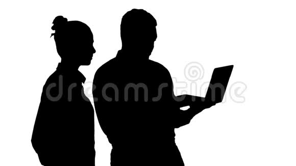 剪影满意他们的工作男人和女人看着笔记本电脑视频的预览图