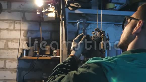 戴眼镜的男性机械师仔细检查车辆细节修理工在车库或车间工作工人使用工具视频的预览图