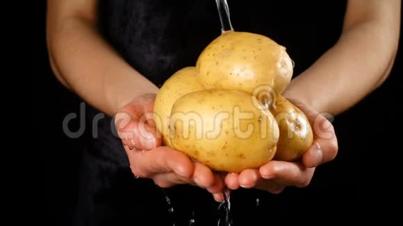 在女人手里洗黄色的土豆慢动作视频的预览图