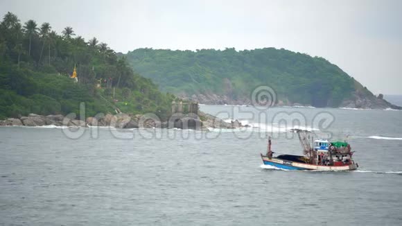 一艘小货船在美丽的热带岛屿附近航行视频的预览图