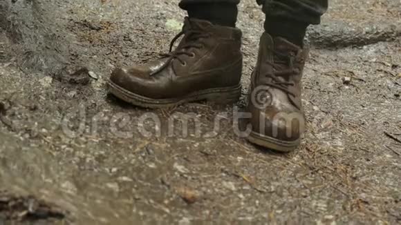 穿着靴子站在地上的旅客特写镜头库存录像登山靴可以经受极端潮湿和泥泞的行走视频的预览图