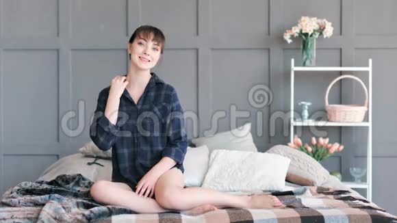 国内年轻漂亮的女孩子穿着衬衫坐在床上在家里全镜头视频的预览图