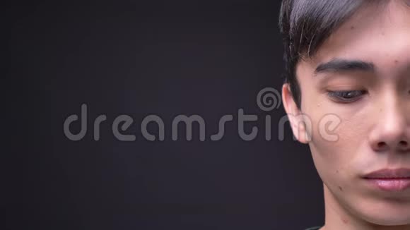 特写半脸的照片年轻迷人的韩国男性脸直视镜头与背景隔离视频的预览图