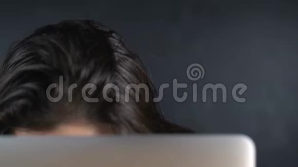 年轻女子戴着眼镜眼睛盯着显示器后面眼睛里闪着光视频的预览图