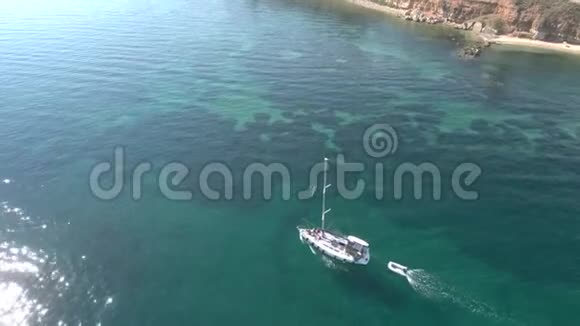 在希腊的哈尔基迪基在绿松石令人惊叹的海面上的帆船的鸟瞰图由无人驾驶飞机自上而下移动视频的预览图