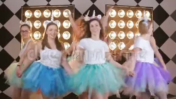 一群快乐的女孩围着新娘跳舞在后台的演播室里庆祝母鸡聚会节日视频视频的预览图
