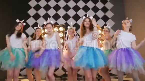 集体女朋友舞战中穿着仙女独角兽的服装五颜六色的空中啧啧裙在镜头上摆姿势跳舞快乐视频的预览图