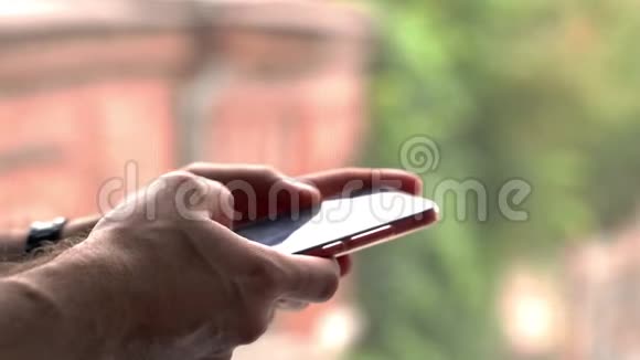 年轻的白种人大人手里拿着智能手机用手指敲着短信视频的预览图