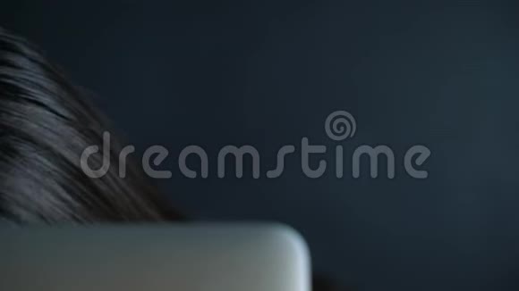 年轻女子戴着眼镜眼睛盯着显示器后面眼睛里闪着光视频的预览图