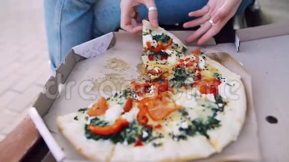 嬉皮士女孩拿了一块新鲜披萨咬了它太阳光线穿过她的眼镜视频的预览图