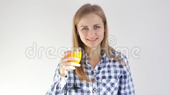 健康的年轻女孩喝橙汁一杯果汁的年轻女子视频的预览图