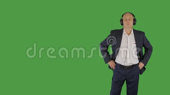 身着商务服的光头男戴着绿色背景耳机听音乐视频的预览图