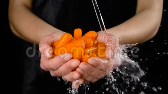 在女人手里洗橙色胡萝卜慢动作视频的预览图