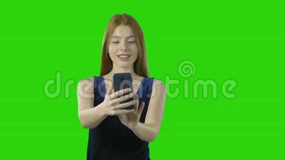 穿着漂亮蓝色连衣裙的红长发女孩通过智能手机在一个孤立的背景下购买视频的预览图