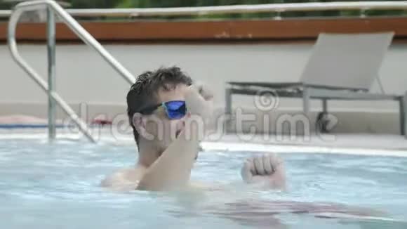夏天的派对上戴太阳镜的快乐男人在泳池里跳舞视频的预览图