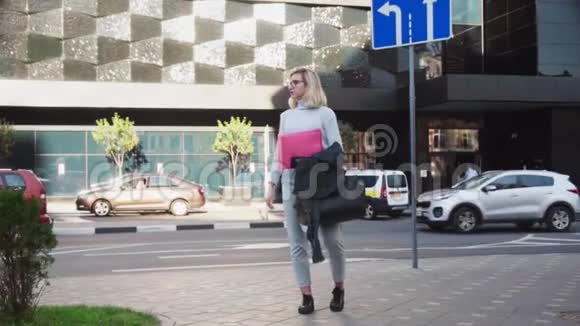 年轻女学生站在城市街道上拿着文件夹找工作视频的预览图