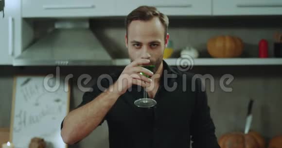 充满魅力的男人直视镜头在万圣节派对上喝一杯鸡尾酒4k视频的预览图