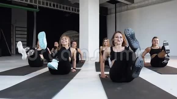 一群年轻的快乐运动员在健身课上在地板上表演健身健美操瑜伽健身运动理念视频的预览图