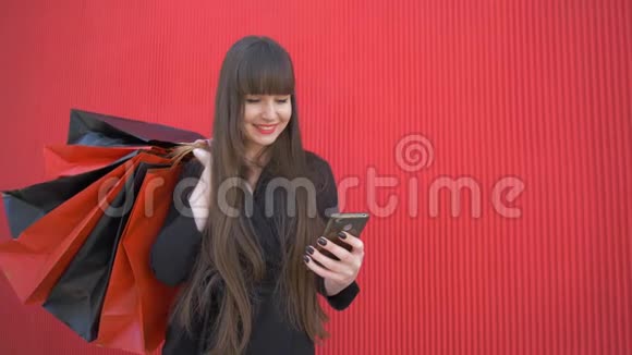 购物时间年轻的快乐女孩在网上购物使用智能手机手里拿着红包视频的预览图
