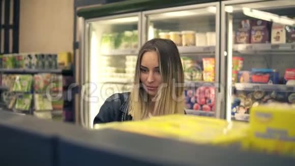 年轻女子在杂货店购物随便女人在超市里从货架上挑选食物微笑的顾客站着视频的预览图