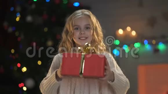 可爱的金发女孩向镜头展示圣诞礼物神奇的节日气氛视频的预览图