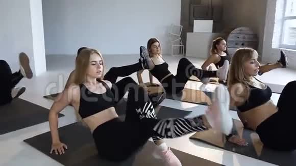 一群年轻运动员和教练一起在健身课上在地板上表演健身健美操瑜伽的概念视频的预览图