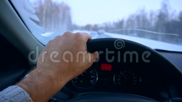 在汽车驾驶过程中用双手特写方向盘冬季公路行驶视频的预览图