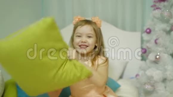 卧室里快乐的小女孩用枕头对着镜头慢镜头视频的预览图