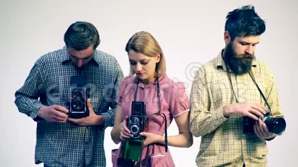 旧相机工作室拍摄的概念三个摄影师调整他们的相机视频的预览图