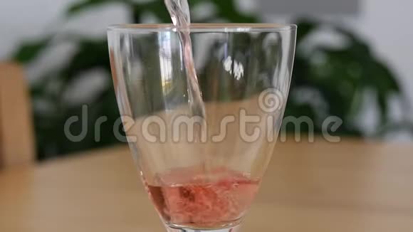 在玻璃杯中倒入粉红色葡萄酒的缓慢动作视频的预览图
