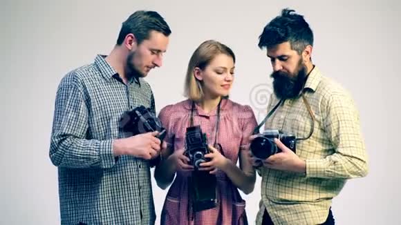 年轻人有兴趣看相机摄影的概念两个男人和一个女孩在做古董视频的预览图