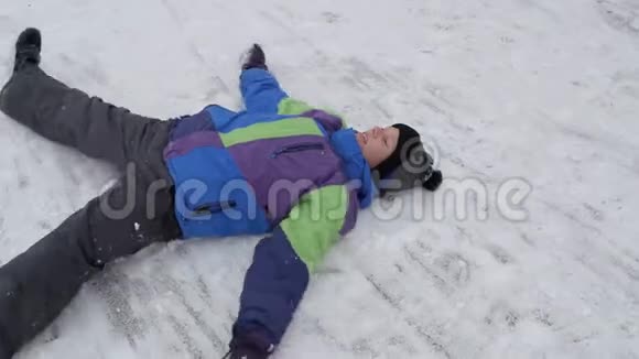 冬天的雪乐趣少年躺在雪地里视频的预览图