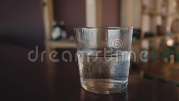 3女孩从桌子上拿出一杯水喝视频的预览图