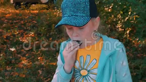 在夏季公园里吃饼干的脸上长着雀斑的姜妹视频的预览图