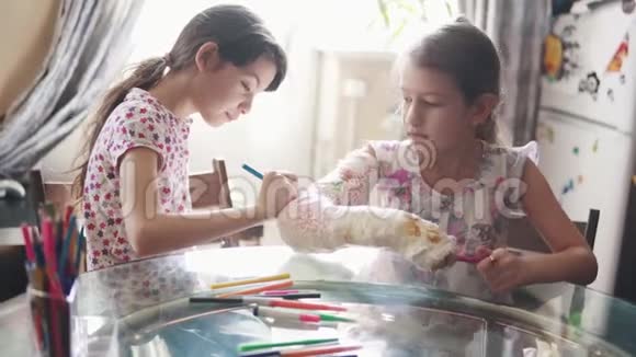 一个可爱的孩子用鲜艳的颜色画着一只涂满灰的手给他妹妹视频的预览图