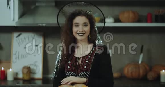 在万圣节派对上一位留着卷发的漂亮亚洲女士戴着女巫的面具在镜头前扮演着非常有魅力的角色视频的预览图