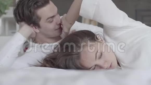 年轻夫妇躺在床上特写女孩生气了转身离开了那个男人二者之间关系的困难视频的预览图