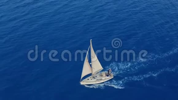 空中观景在开阔的大海上航行着白帆的游艇视频的预览图
