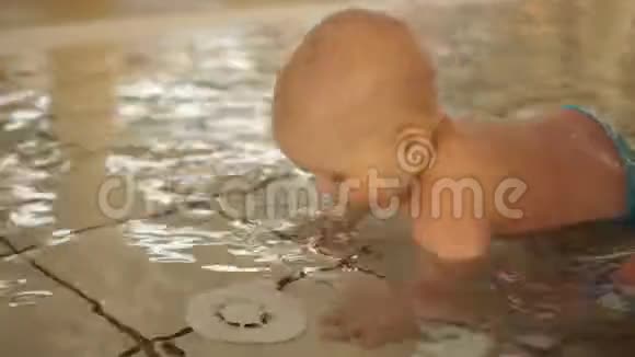 婴儿在一个浅暖和的游泳池里为孩子们爬行加强免疫力在水上乐园休息视频的预览图