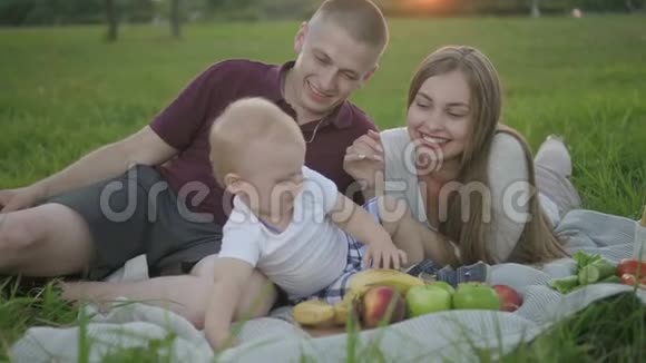 父亲母亲婴儿坐在公园里玩得很开心视频的预览图