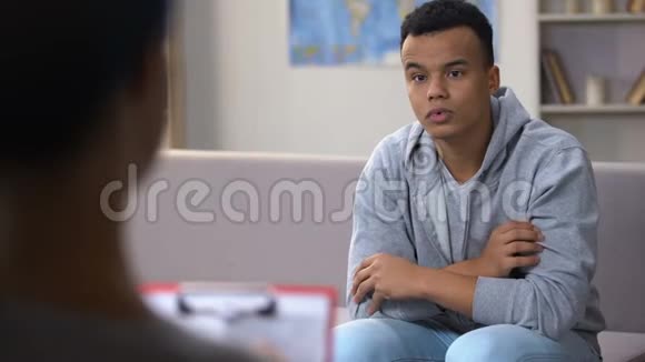 沮丧的非裔美国青少年与心理学家交谈学校里的种族主义视频的预览图