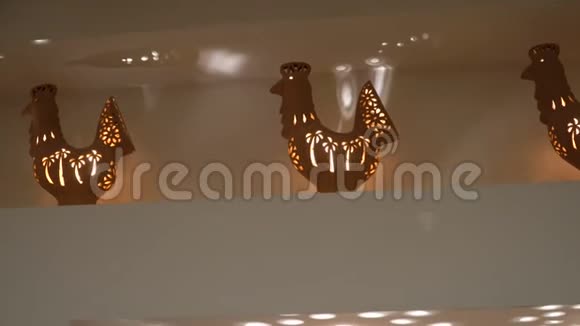 架子上以公鸡形式的粘土花瓶蜡烛在里面燃烧家庭内部和舒适视频的预览图