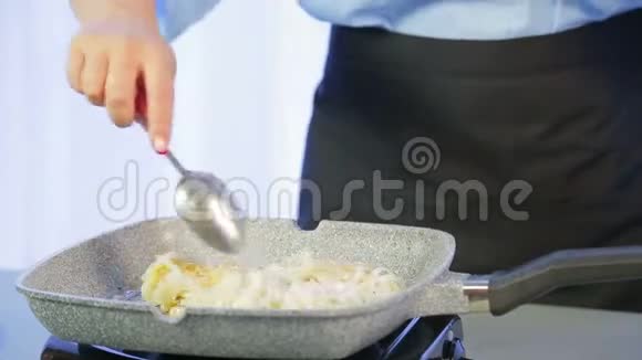 一个女人正在煎锅里用木抹子拌米粉视频的预览图
