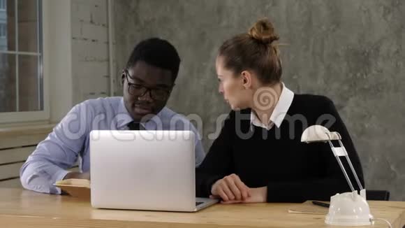 两个企业家坐在一起在办公桌上工作把笔记记在笔记本上视频的预览图