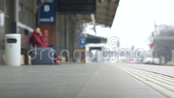 腿的特写沿着火车站的站台走一个手提箱正在附近搬运运输和视频的预览图